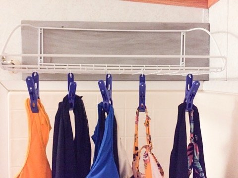 This easy shower shelf is the best solution for drying swimsuits without a mess this summer. #pool #swimmingpool #swimsuits #showershelf #bathroom #momhacks #summervacation