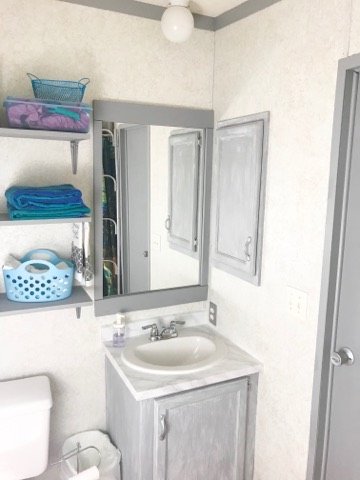 newly renovated grey and white bathroom with white marble counters